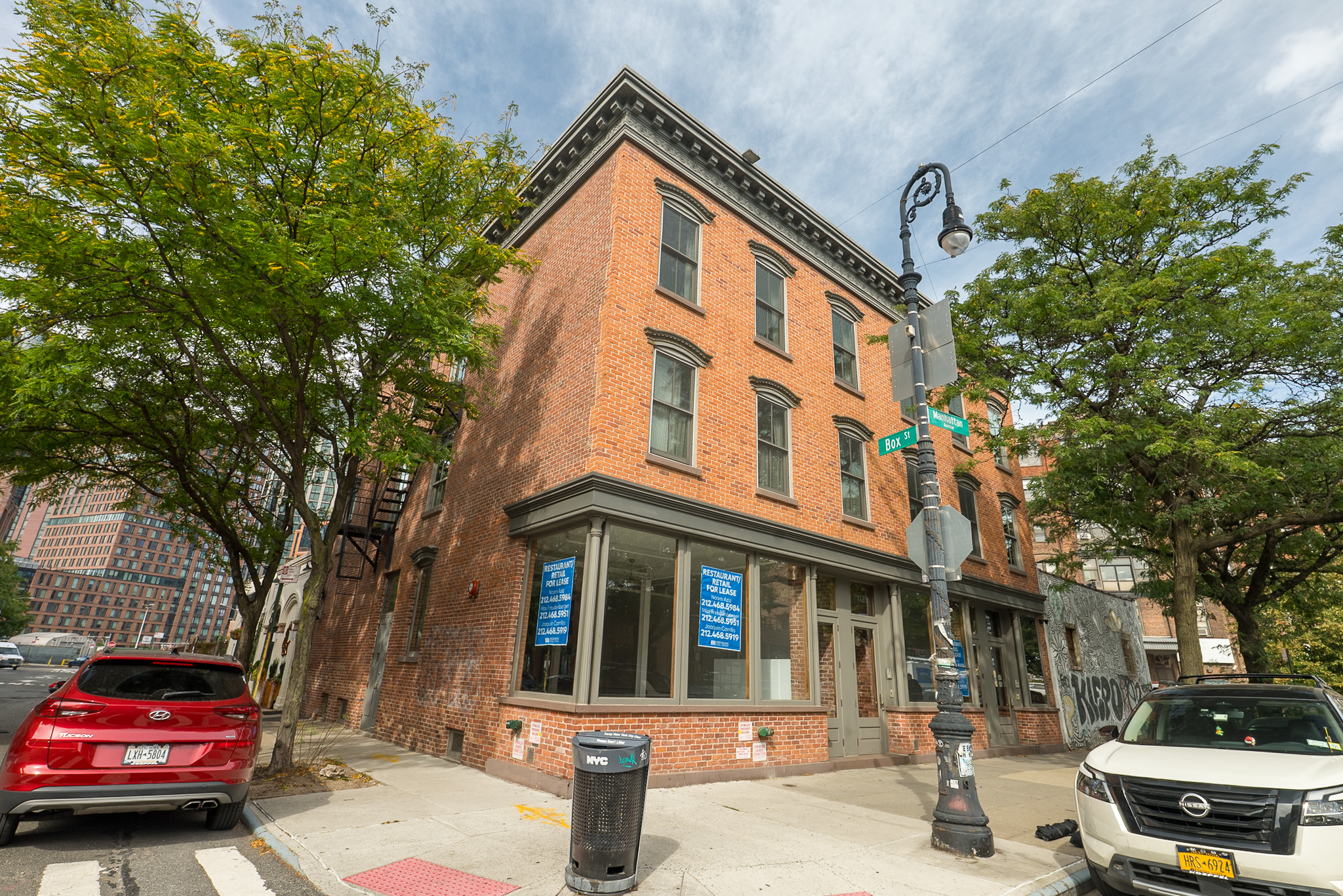 Three-story brick corner building with ground-floor storefront windows