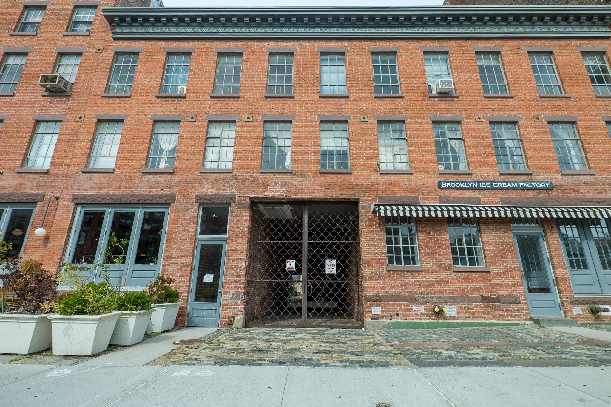 Street-facing brick building facade with rows of windows and ground-floor entrances